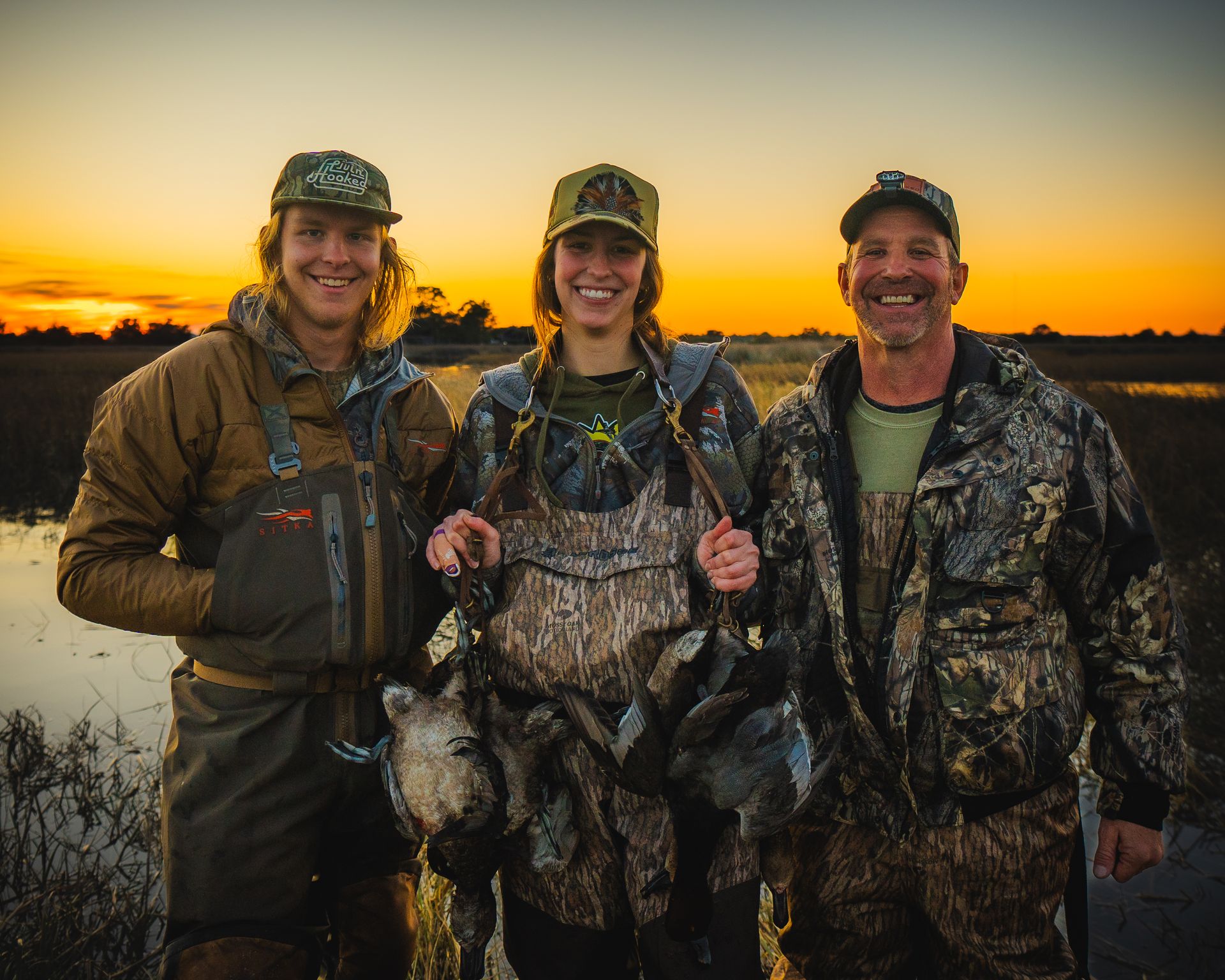 Duck hunters at sunset marsh