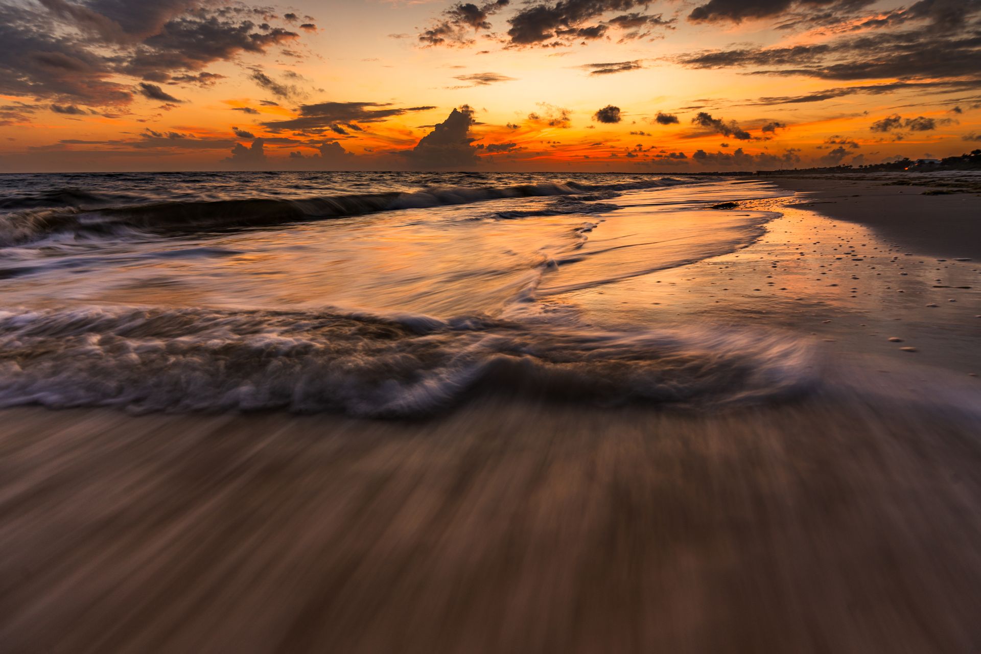 Waves crashing on beach at golden hour