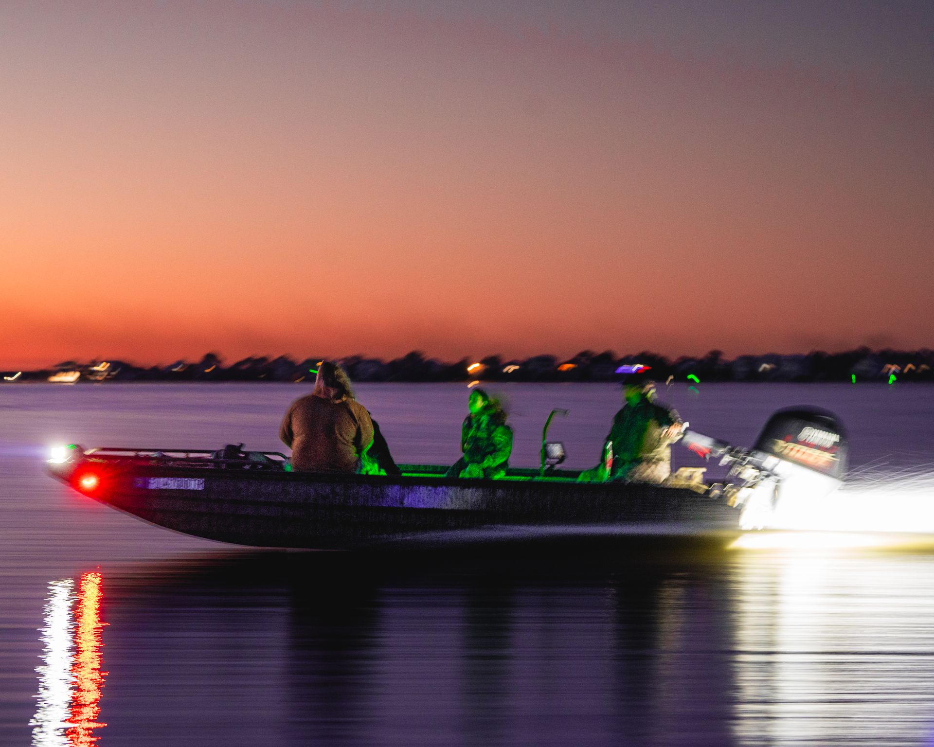 Hunting boat at twilight with green lights